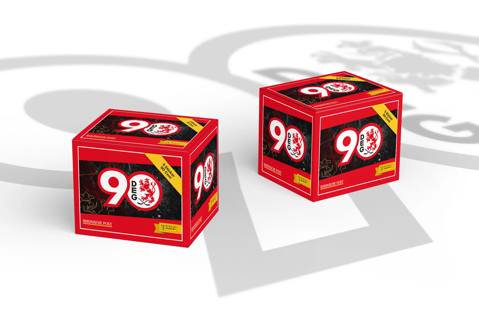 Mockup zweier roter Sammelboxen mit dem Aufdruck ‚90 Jahre DEG‘, gestaltet im Look des Stickeralbums der Düsseldorfer EG, mit Eishockey-Löwenmotiv und gelbem Panini-Hinweis auf weißem Hintergrund mit Schattenlogo.